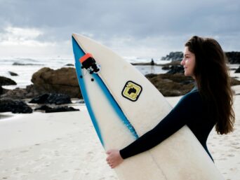 Female Surfer Holding Board on Rocky Australian Beach